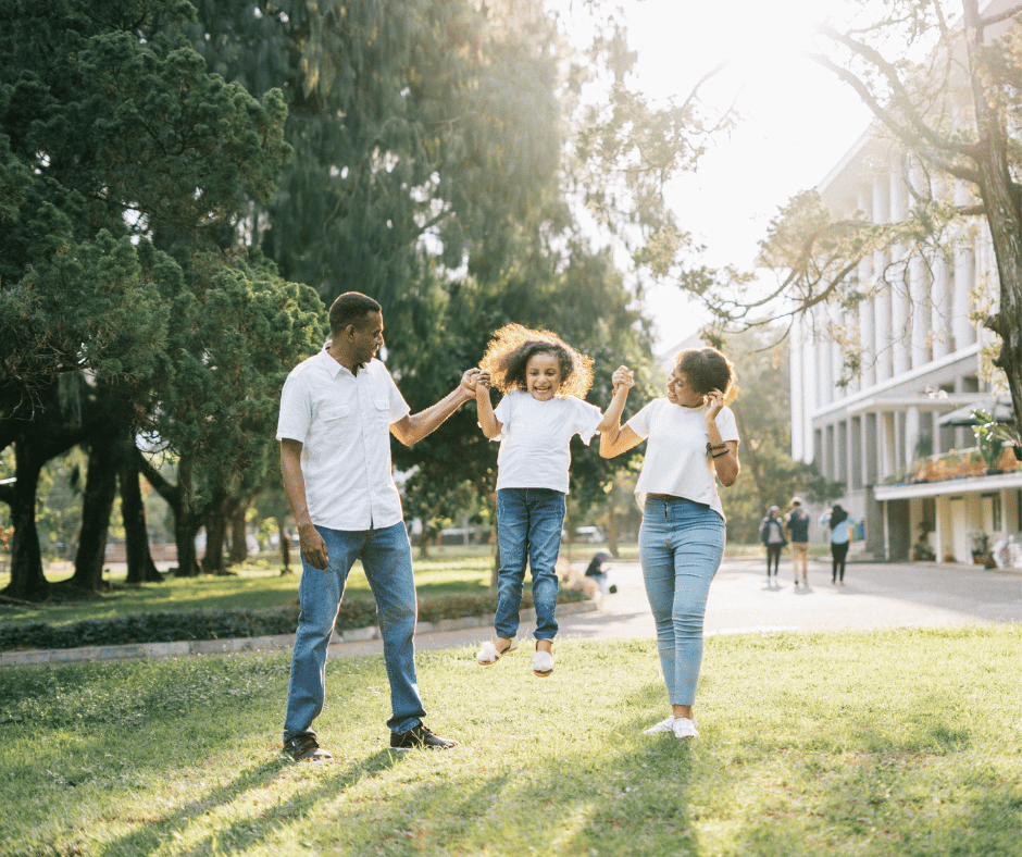 A family happily playing together in a park, enjoying each other, a sunny day